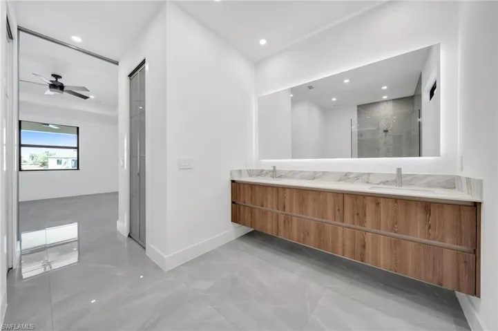 Bathroom with a stall shower, double vanity, and recessed lighting