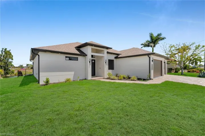 Prairie-style home with a shingled roof, an attached garage, decorative driveway, and stucco siding