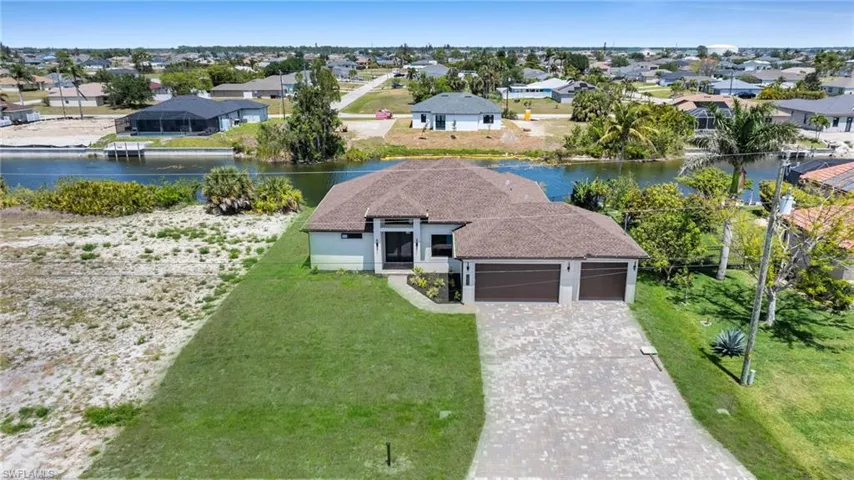 Aerial perspective of suburban area featuring a nearby body of water
