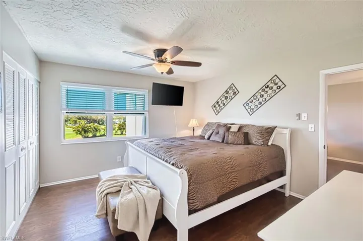 Master Bedroom with a closet, dark wood-style floors, a textured ceiling, and a ceiling fan
