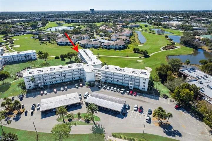 Aerial view of property's location featuring a golf course and a nearby body of water