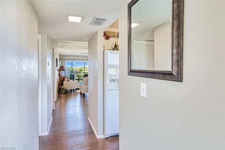 Hallway with dark wood-style flooring and baseboards