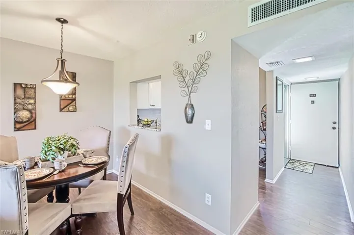Dining area with dark wood-style flooring and a textured ceiling