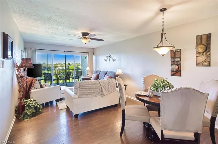 Living room with hardwood / wood-style floors, a textured ceiling, and ceiling fan