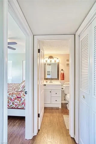 Corridor with a textured ceiling and light wood-style flooring