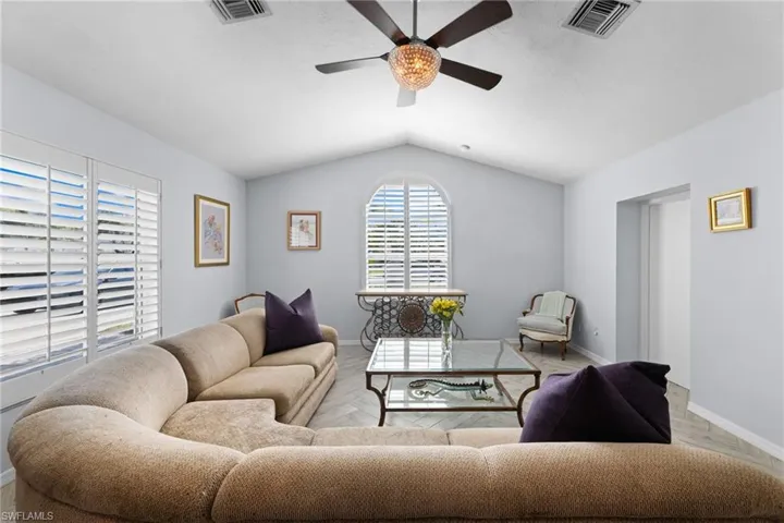 Living room with lofted ceiling and ceiling fan