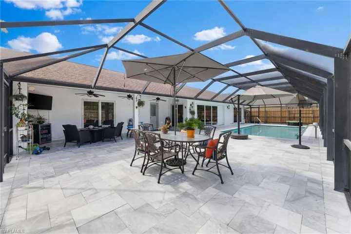 View of patio / terrace with a fenced in pool, ceiling fan, and a lanai