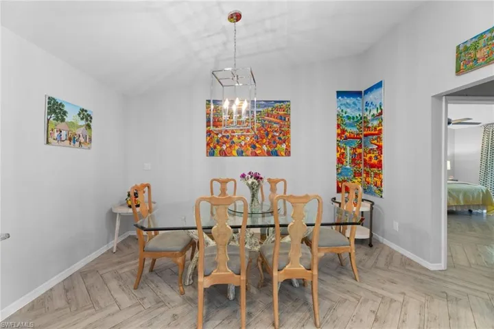 Dining space featuring an inviting chandelier and light parquet floors