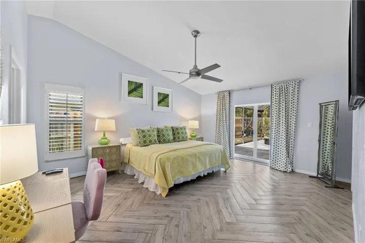 Bedroom with ceiling fan, access to exterior, lofted ceiling, and light parquet floors