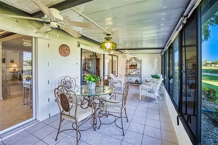 Sunroom with a ceiling fan and outdoor dining area