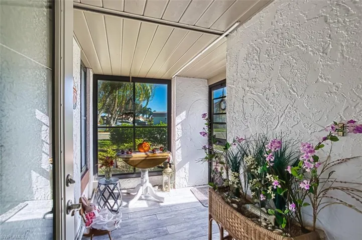 Sunroom featuring a textured wall, hardwood / wood-style floors, and wooden ceiling