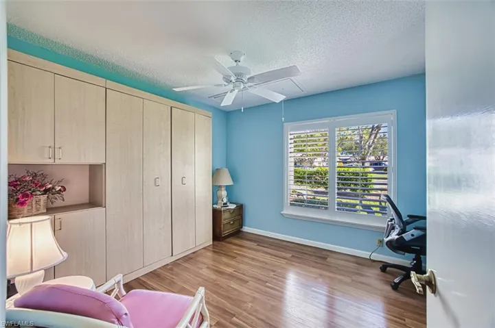 Home office featuring light wood-type flooring, a textured ceiling, and ceiling fan