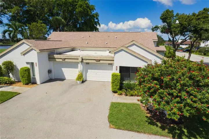 View of front of property with driveway, stucco siding, roof with shingles, and a garage
