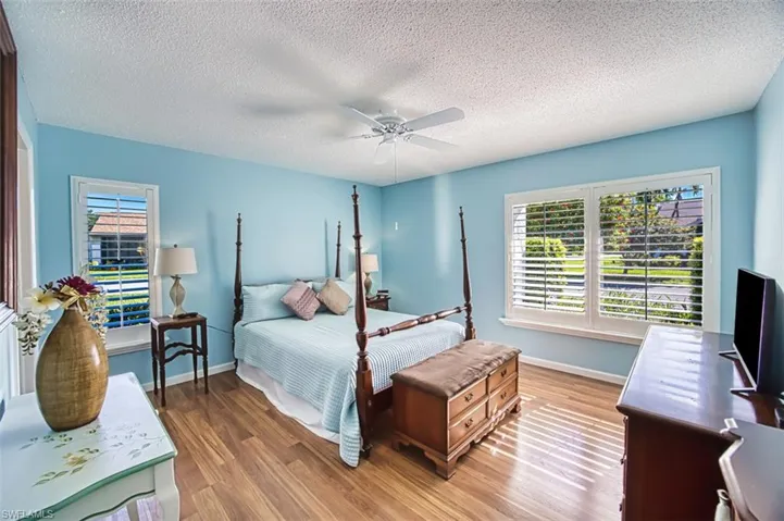 Bedroom featuring wood finished floors, a textured ceiling, and ceiling fan