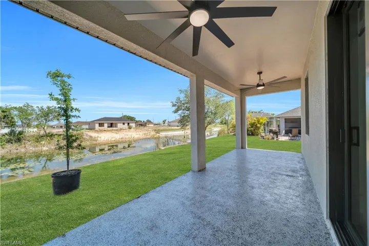 View of patio featuring a water view and a ceiling fan