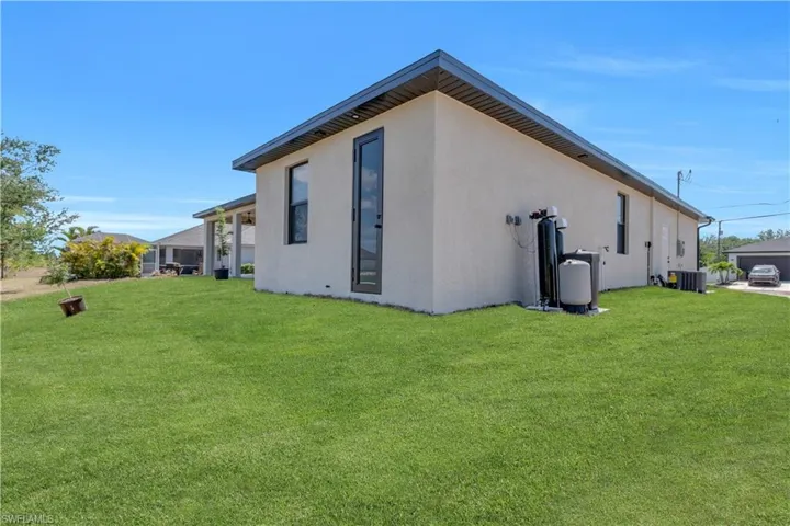 View of side of property with stucco siding and a lawn