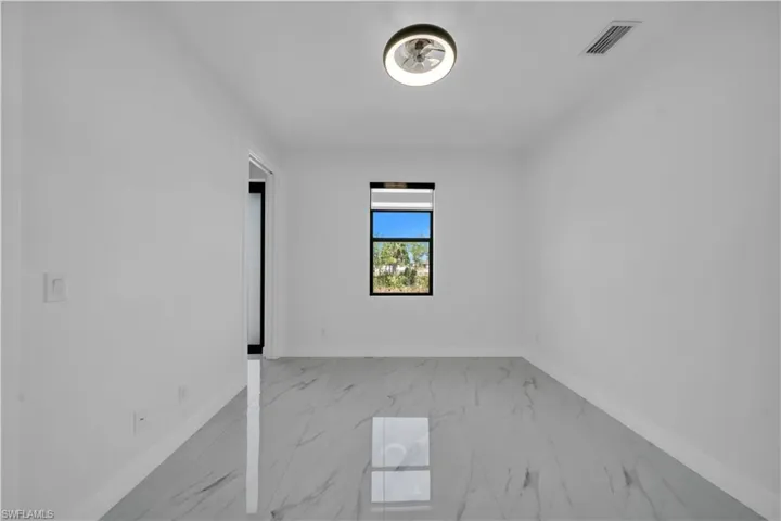 Empty room featuring light marble finish floors and baseboards