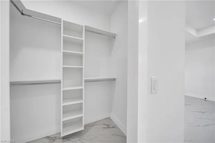 Spacious closet with light marble finish floors