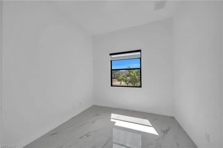 Unfurnished room with light marble finish floors and baseboards