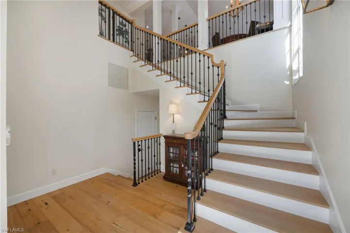 Staircase featuring hardwood / wood-style flooring and a high ceiling
