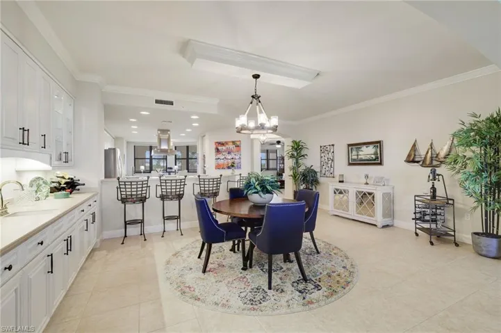 Dining room with crown molding and chandelier, built in wet bar with storage.