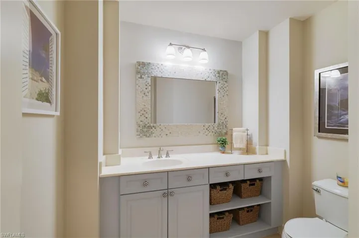 Guest Half Bathroom featuring vanity with open storage.