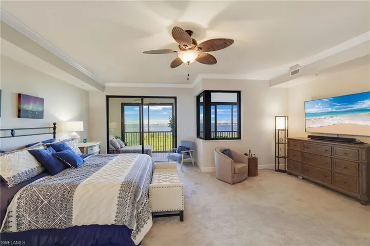 Primary Bedroom featuring crown Molding, direct access to lanai and spectacular views of Caloosahatchee River.