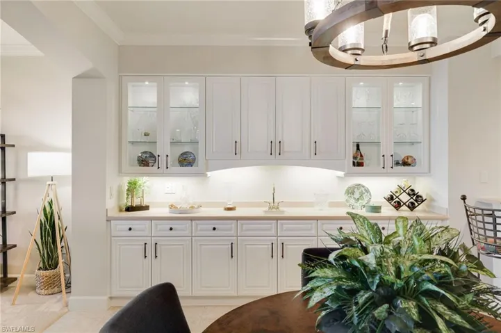 Built In wet bar featuring 42" glass  cabinets with accent lighting and under counter storage.