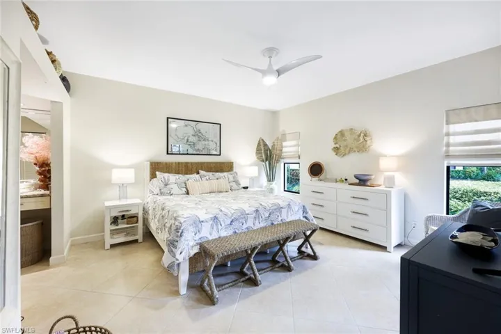 Tiled bedroom featuring ceiling fan
