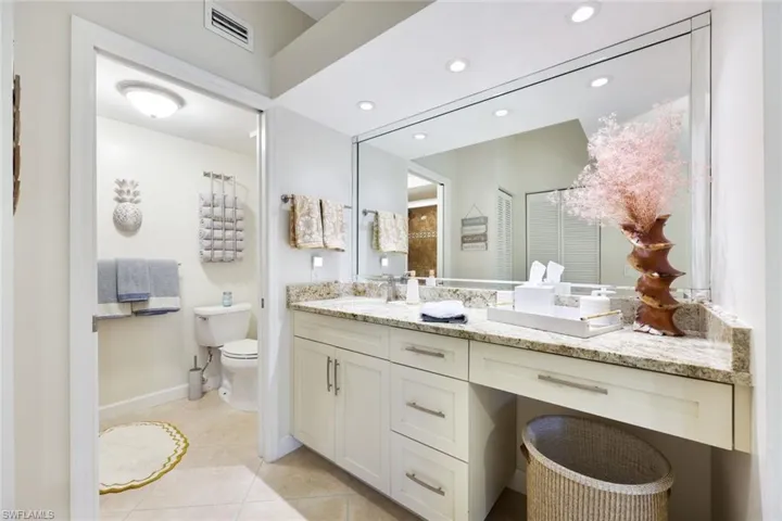 Bathroom featuring tile patterned flooring, toilet, and dual bowl vanity