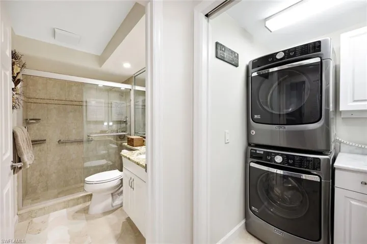 Laundry room featuring stacked washer / dryer and light tile patterned floors