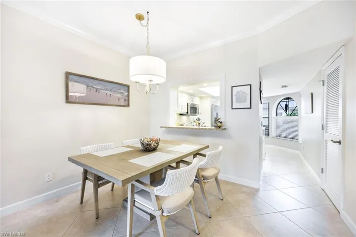 Tiled dining area featuring crown molding