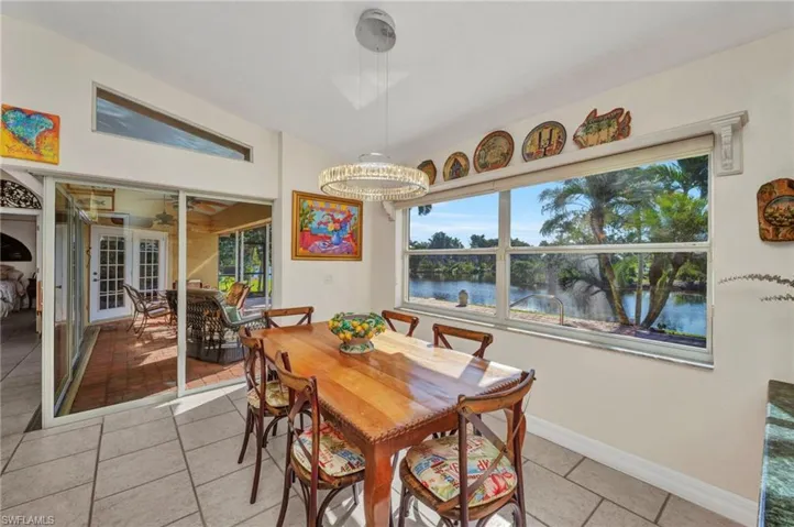 Dining area featuring a water view, light tile patterned floors, and a chandelier