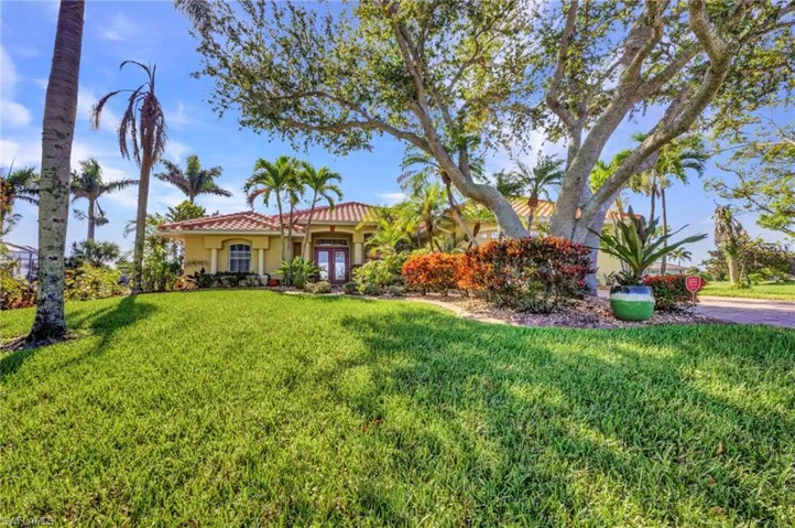 Mediterranean / spanish-style house featuring a front lawn, stucco siding, and a tile roof
