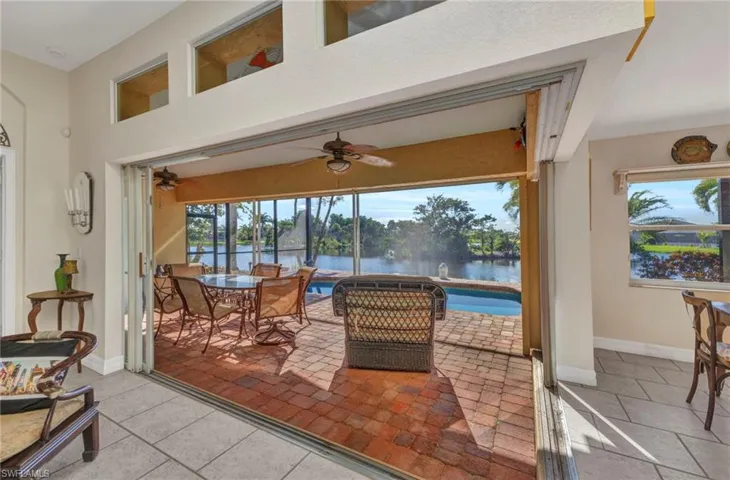 Sunroom with ceiling fan, a water view, and outdoor dining space