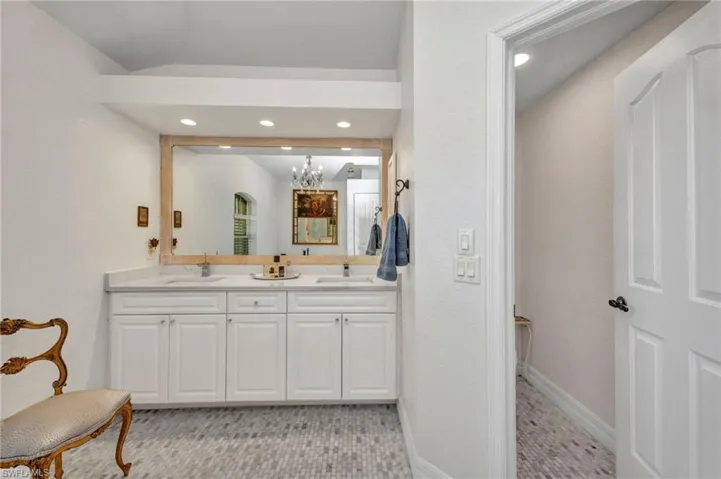 Bathroom featuring double vanity, recessed lighting, and a chandelier