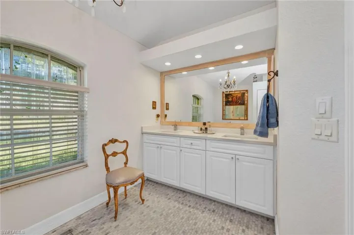 Bathroom with a chandelier, double vanity, and recessed lighting