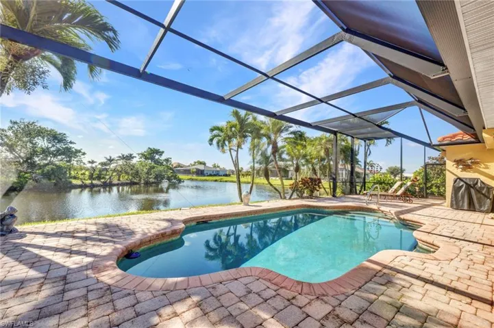 Swimming pool featuring a patio, a water view, and a lanai