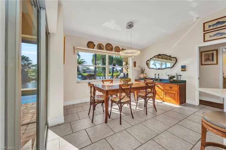 Dining area with lofted ceiling and light tile patterned flooring