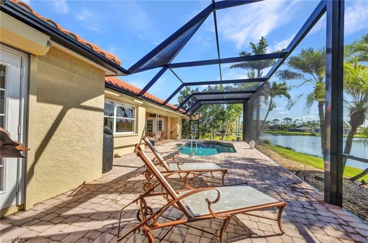 View of patio / terrace with a water view, an outdoor pool, and glass enclosure