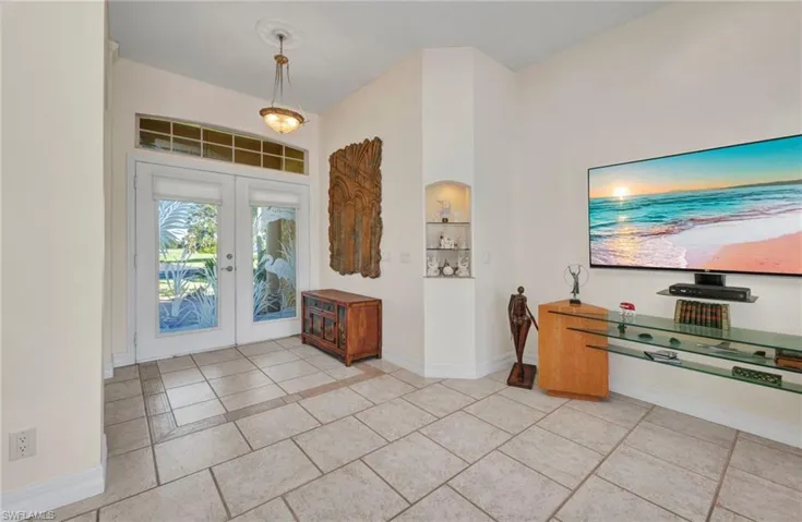 Entrance foyer with french doors and light tile patterned flooring