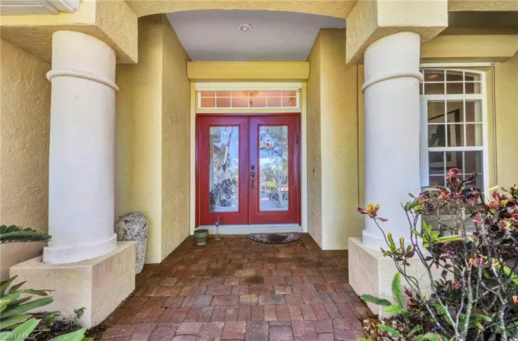 View of exterior entry featuring french doors and stucco siding