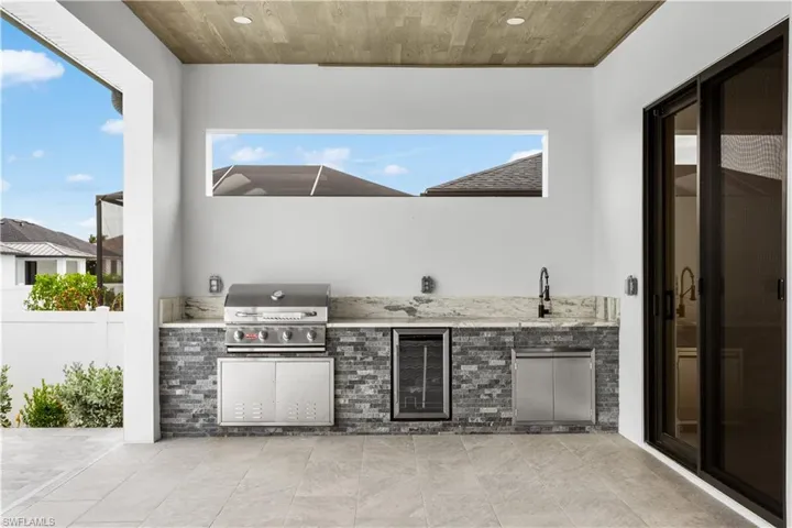 OUTDOOR KITCHEN with BBQ GRILL, MINI-REFRIGERATOR, and COMMERCIAL SINK offers the perfect setting for AL FRESCO DINING and ENTERTAINING!