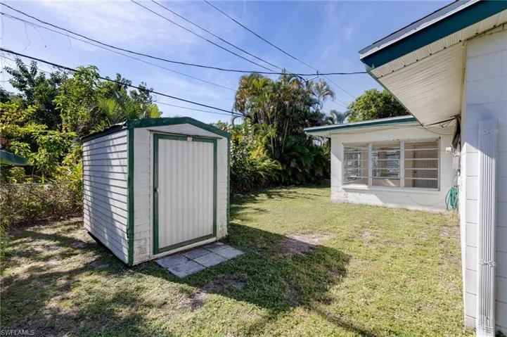 View of green lawn with a storage shed