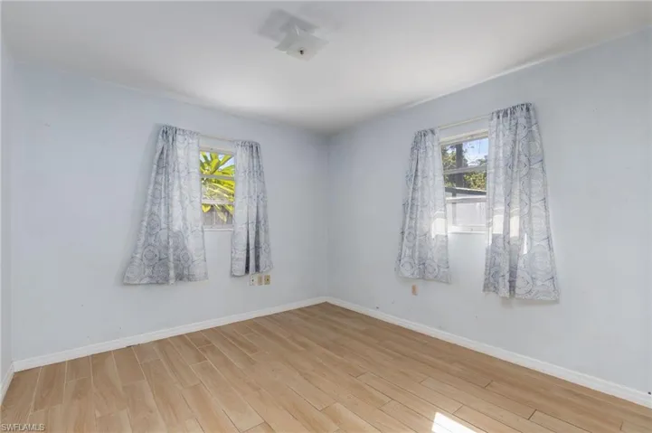 Unfurnished room featuring baseboards and wood finished floors