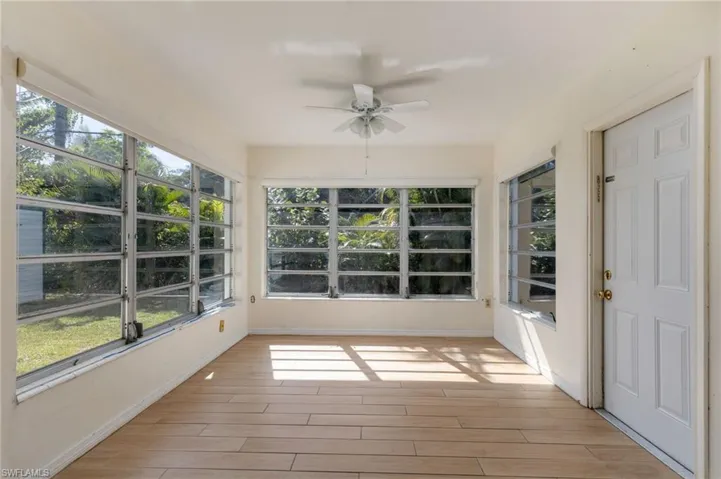 Unfurnished sunroom featuring wood finished floors and baseboards