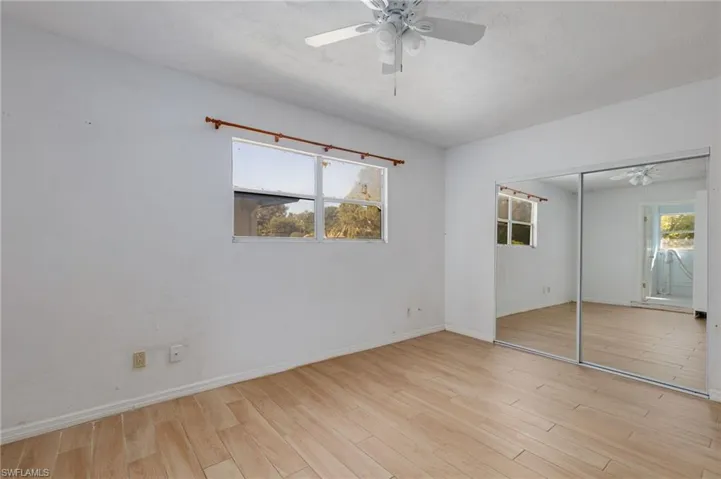 Unfurnished bedroom with multiple windows, light wood-type flooring, a closet, and a ceiling fan
