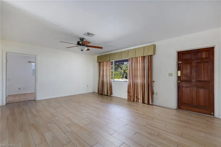 Unfurnished living room with a ceiling fan and light wood-type flooring
