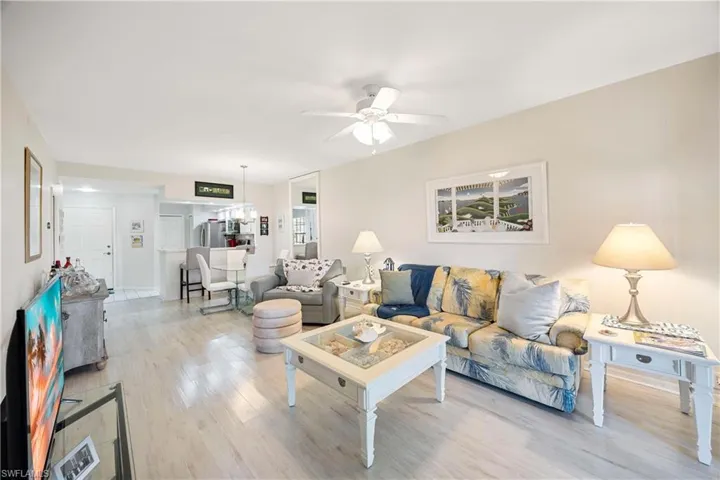 Living area with light wood-style floors and a ceiling fan