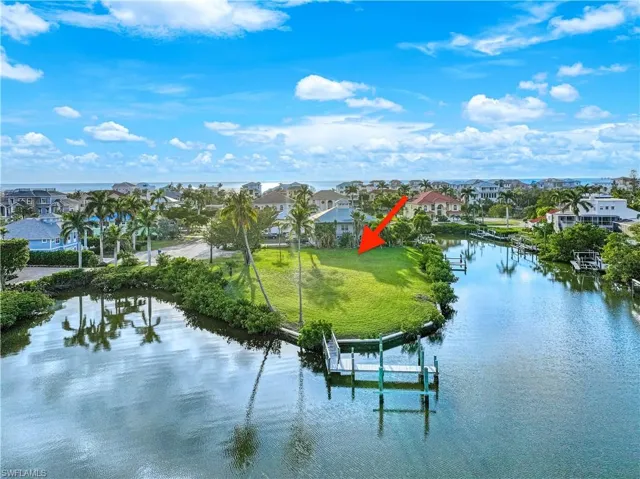 Water view with a boat dock, nearby suburban area, and boat lift